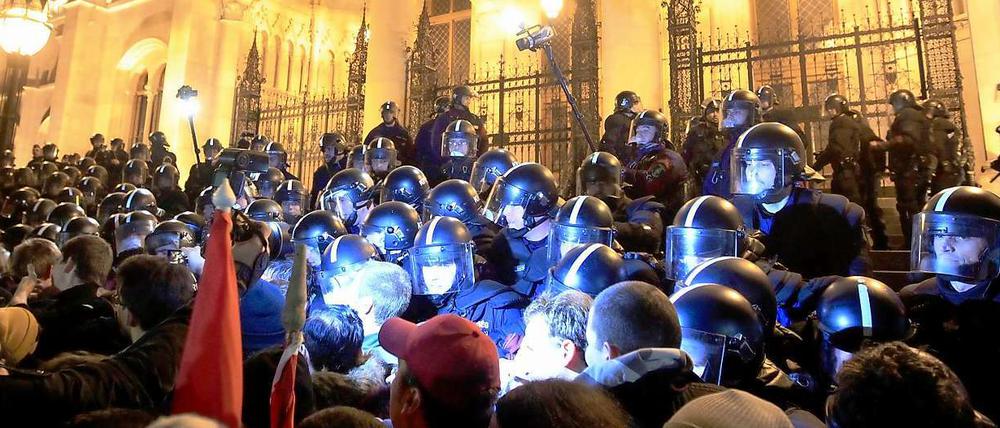 Polizei riegelt am Montagabend das Parlament in Budapest vor der Menge der Demonstranten ab. 