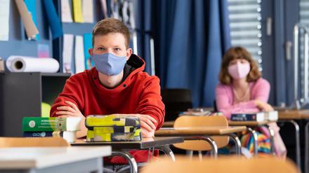 Schüler und Schülerinnen einer 12. Klasse des Lise-Meitner-Gymnasiums in Bayern nehmen am Unterricht teil und tragen Mundschutze.