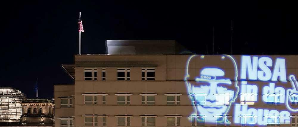 Der Schriftzug "NSA in da House" und das stilisierte Victory-Zeichen werden in der Nacht zum 19. Juli 2014 in Berlin auf die Fassade der nahe dem Reichstag gelegenen US-Botschaft projiziert. Die minutenlange Projektion war eine Aktion des Düsseldorfer Lichtkünstlers Oliver Bienkowski.