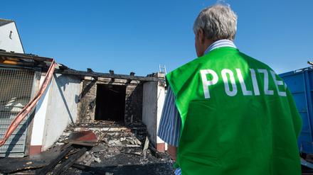 Ein Spurenermittler der Polizei steht am 16.07.2015 in Reichertshofen (Bayern) vor einem ehemaligen Landgasthof, der in den frühen Morgenstunden in Brand geraten war. Unbekannte haben in der Nacht zum Freitag einen Brandanschlag auf eine Asylbewerberunterkunft in der Oberpfalz verübt. 