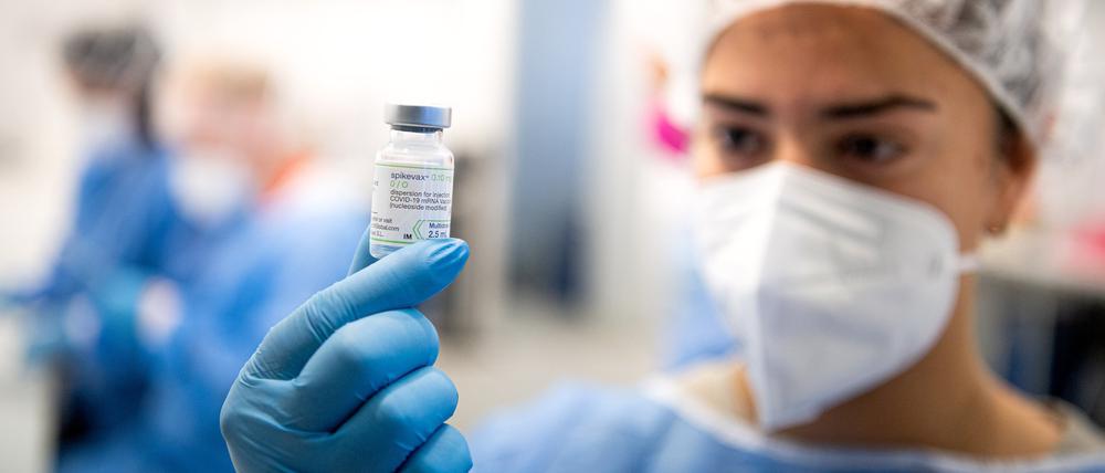 Eine Impfzentrum-Mitarbeiterin hält eine Flasche vom Spikevax Impfstoff von Moderna.