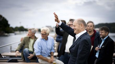 SPD-Kanzlerkandidat winkt auf der Havel Ruderern zu, die ihn grüßen. 