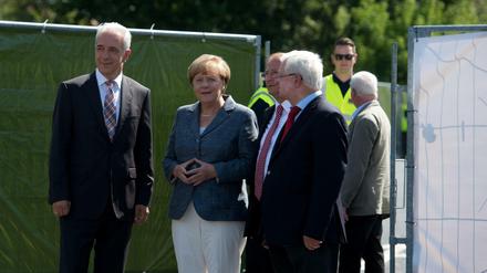 Bundeskanzlerin Angela Merkel (CDU) trifft an der Flüchtlingsunterkunft in Heidenau (Sachsen) ein und wird von dem DRK Präsidenten Rudolf Seiters (r), dem Ministerpräsidenten von Sachsen Stanislaw Tillich (CDU, l) und dem Bürgermeister von Heidenau Jürgen Opitz (3.v.l.) begrüßt. 