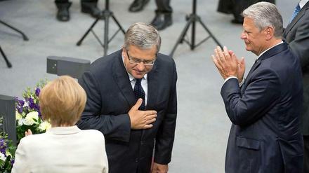 75 Jahre nach dem Beginn des Zweiten Weltkriegs würdigt Polens Präsident Bronislaw Komorowski (Mitte) das „Wunder der Versöhnung“ im Bundestag. Kanzlerin Angela Merkel und Bundespräsident Joachim Gauck applaudieren. 