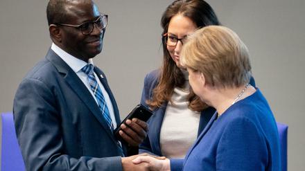 Bundeskanzlerin Angela Merkel (CDU) unterhält sich im Bundestag mit Karamba Diaby und Yasmin Fahimi (beide SPD). 