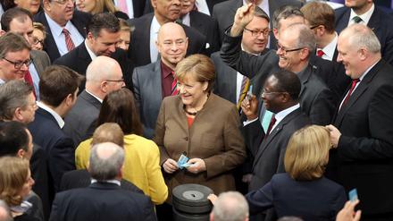 Geschafft, wenn auch mit Gegenstimmen: Die Kanzlerin und Abgeordnete der Koalition - Unionsfraktionschef Volker Kauder (links von Merkel) und der SPD-Politiker Karamba Diaby (rechts) am Donnerstag bei der Stimmabgabe zum Asylpaket II .