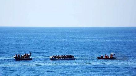 Zwei Rettungsboote der Bundeswehr nähern sich am Donnerstag einem Schlauchboot mit Flüchtlingen.