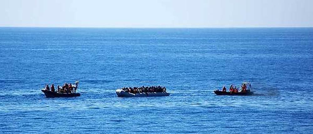 Zwei Rettungsboote der Bundeswehr nähern sich am Donnerstag einem Schlauchboot mit Flüchtlingen.