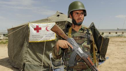 Ein Bundeswehrsoldat bewacht ein Zelt des Roten Kreuzes in Afghanistan.