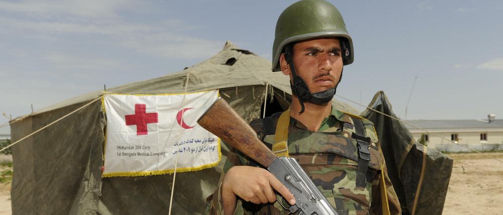 Ein Bundeswehrsoldat bewacht ein Zelt des Roten Kreuzes in Afghanistan.