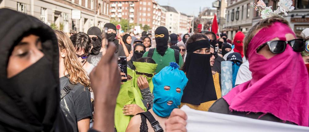 01.08.2018, Dänemark, Kopenhagen: Demonstranten haben bei einem Protest gegen das Verbot von Burkas und Nikabs teilweise ihr Gesicht verhüllt. 