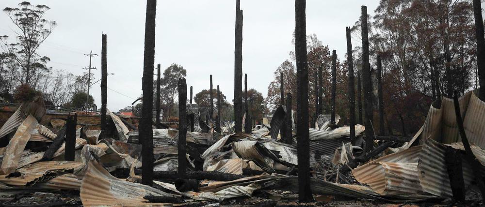 Verbrannte Baumstämme ragen aus Blechtrümmern auf einem vom Buschfeuer zerstörten Areal in Mogo, ungefähr 160 Kilometer südöstlich der australischen Hauptstadt Canberra.