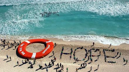 Zuversichtlich: Eine Aktion von Klimaschützern am Strand con Cancún.