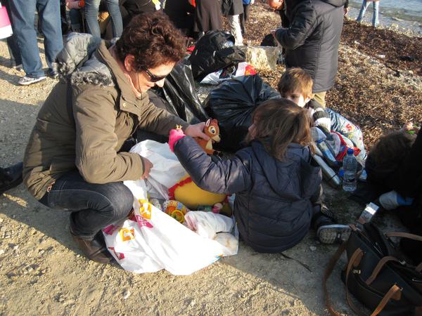 Christina Chatzidaki auf einem Foto von 2015 am Strand von Lesbos mit Kindern, die soeben neu auf der Insel angekommen sind.