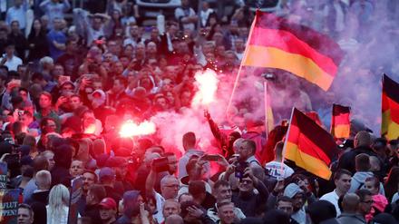Demonstranten der rechten Szene zünden in Chemnitz Pyrotechnik und schwenken Deutschlandfahnen. 