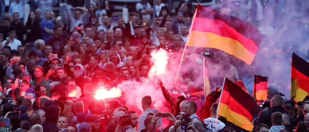 Demonstranten der rechten Szene zünden in Chemnitz Pyrotechnik und schwenken Deutschlandfahnen. 