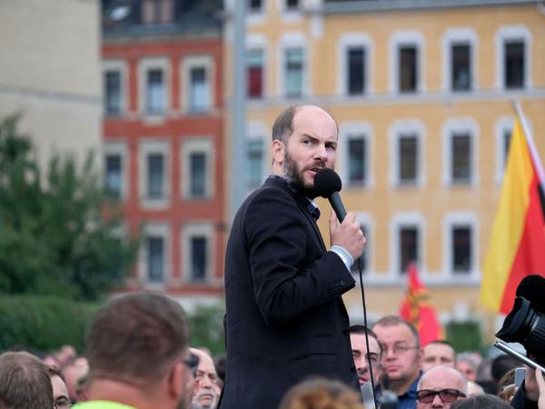 Martin Kohlmann von Pro Chemnitz spricht während des Kretschmann-Besuchs bei einer Demonstration vor dem Stadion. 