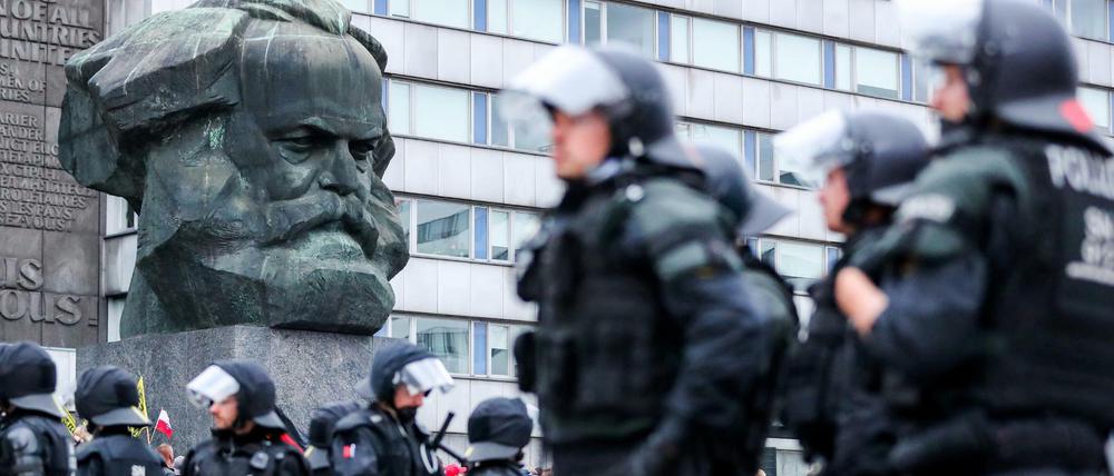Polizisten sichern eine Demonstration der rechten Szene vor dem Karl-Marx-Denkmal in Chemnitz.