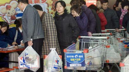 Menschen kaufen in einem Supermarkt in Qingdao, China, ein, dabei benutzen sie Plastiktüten.