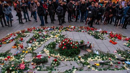 Besucher des Weihnachtsmarktes legen im Gedenken an die Opfer des Terroranschlags Blumen am Breitscheidplatz nieder.