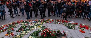 Besucher des Weihnachtsmarktes legen im Gedenken an die Opfer des Terroranschlags Blumen am Breitscheidplatz nieder.