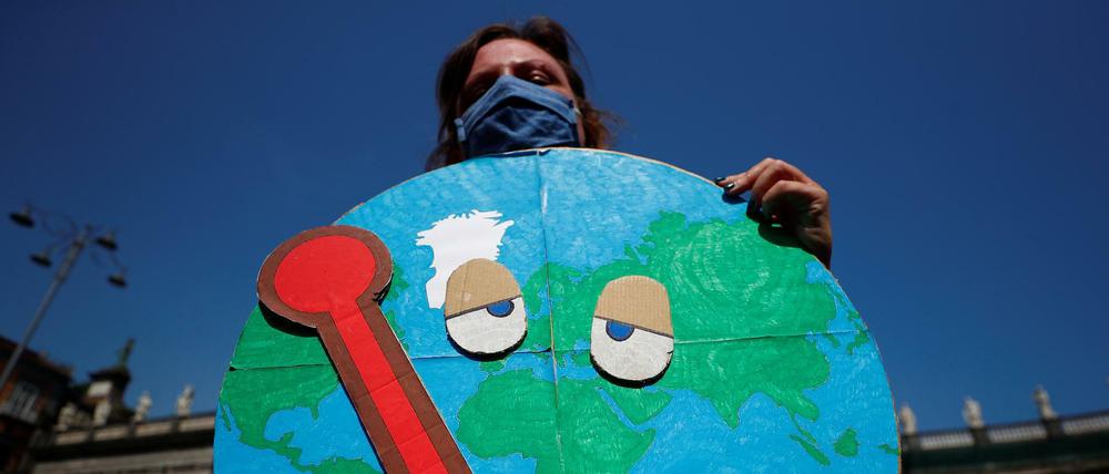 Eine Demonstrantin hält eine kranke Erde bei einem Protest anlässlich des Terffens der G20-Umweltminister in Neapel.