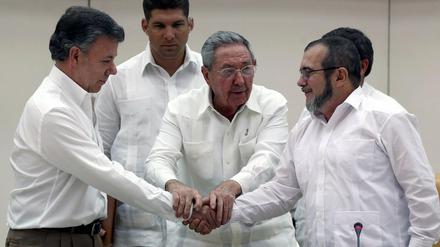 Aussicht auf Frieden in Kolumbien: Präsident Juan Manuel Santos (links) und Rebellenführer "Timochenko" (rechts) besiegeln die Einigung, in der Mitte Kubas Präsident Raul Castro. 