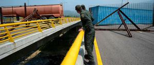 Kolumbianische Polizisten betrachten die von Venezuela gesperrte Brücke.