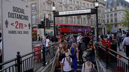 Pendler, die aufgrund von Covid-19 Gesichtsbedeckungen tragen, betreten am 7. Juni 2021 die Londoner U-Bahn-Station Oxford Circus im Zentrum von London.