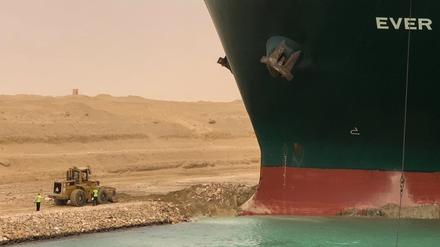Ein Bagger versucht, das vordere Ende des von Evergreen Marine betriebenen Containerschiffs Ever Given zu befreien, nachdem es im südlichen Ende des Suezkanals auf Grund gelaufen ist und den Schiffsverkehr in beide Richtungen blockierte.  