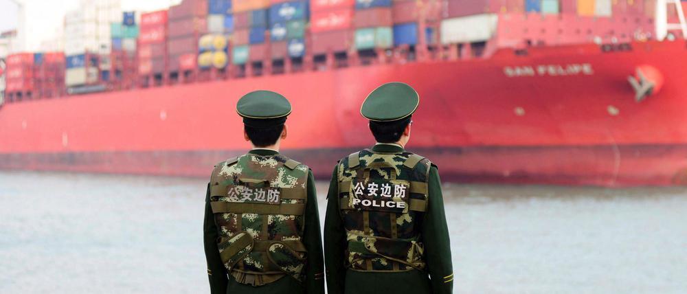 Qingdao: Polizisten beobachten die Ankunft eines Containerschiffs.