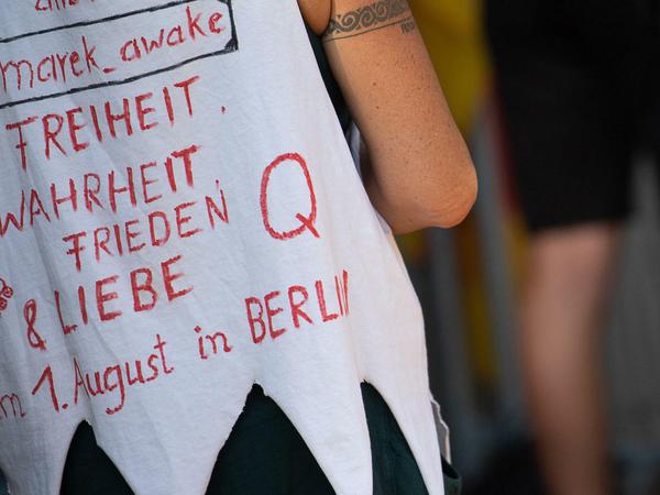 Eine Frau trägt während einer Anti-Corona-Kundgebung in Stuttgart ein Shirt mit einem "Q" darauf. 