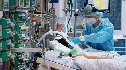 Ein Intensivpfleger kümmert sich in der Uniklinik Gießen um einen Covid-19-Patienten.