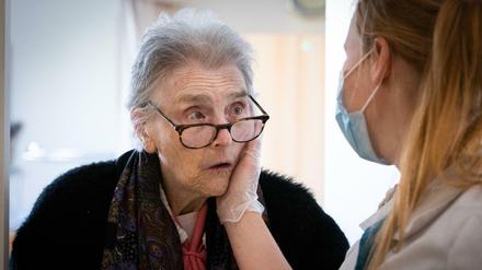 Eine Krankenschwester hält mit einer Hand das Gesicht einer Bewohnerin des Pflegeheims "La Retraite Fleurie" in Belgien.