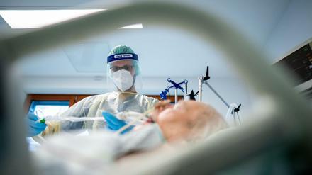 Ein Intensivpfleger versorgt im Berliner Krankenhauses Bethel einen Corona-Patienten.