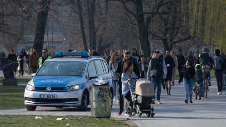 Eine Polizeistreife fährt Ende März durch den Treptower Park in Berlin und fordert die Menschen auf, die Wiese zu verlassen. 