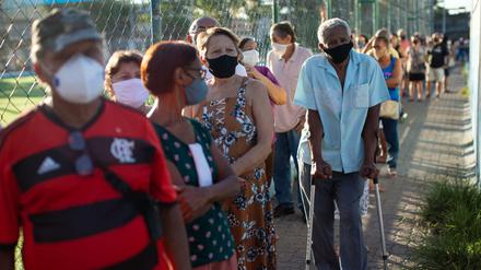 Menschen über 70 Jahren stehen Schlange vor einem Impflokal in Brasilien.