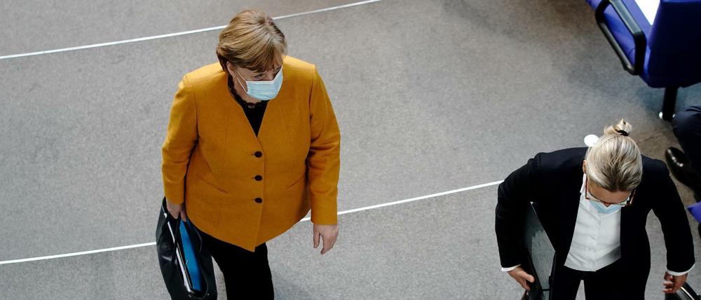 Bundeskanzlerin Angela Merkel (l, CDU) verlässt ihren Platz neben Alice Weidel, Fraktionsvorsitzende der AfD, nachdem sie im Bundestag bei der Regierungsbefragung die Fragen der Bundestagsabgeordneten beantwortet hat. Ein Hauptthema sind die Oster- und Lockdown-Beschlüsse der Bund-Länder-Konferenz zu der Corona-Pandemie. 
