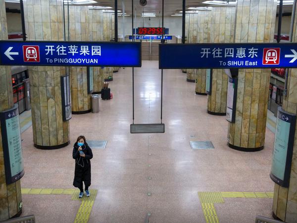 Wie leergefegt: Eine Frau geht während des morgendlichen Berufsverkehrs durch eine normalerweise stark frequentierte U-Bahn-Station in Peking.
