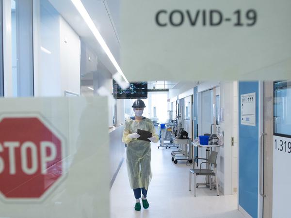 Eine Krankenpflegerin geht den Gang auf der Corona-Intensivstation im Universitätsklinikum Dresden entlang.