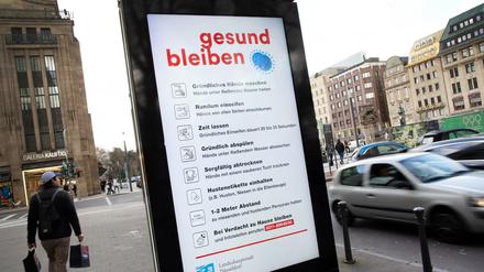 Auf einer Tafel werden in der Innenstadt von Düsseldorf Verhaltensregeln zum Coronavirus angezeigt. 