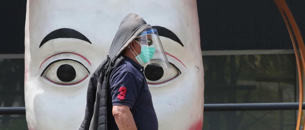 Ein Mann mit Gesichtsmaske und Mundschutz in Quito, Ecuador