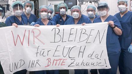 Das Team der Zentralen Notaufnahme der Uniklinik in Essen appelliert mit dem Spruchband "Wir bleiben für euch da! Und ihr bitte zu Hause!" an die Bevölkerung. 