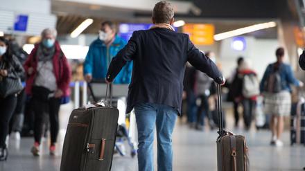Ein Passagier läuft mit seinem Gepäck durch den Flughafen Frankfurt.