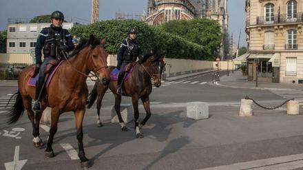 Berittene Polizisten patrouillieren neben der Kathedrale Notre Dame. 