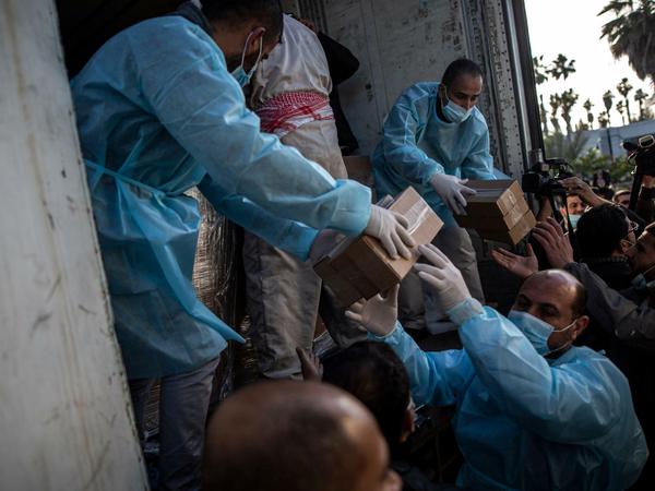 Palästinenser entladen Kisten mit dem russischen Corona-Impfstoff Sputnik V im Gazastreifen, den die Vereinigten Arabischen Emirate gespendet haben. 