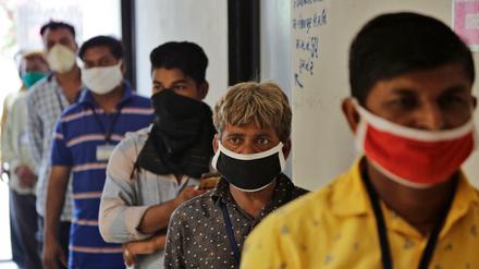 Straßenhändler stehen vor einem Gesundheitszentrum in Indien Schlange, um einen Corona-Test durchzuführen.