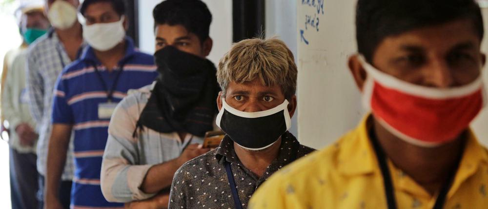 Straßenhändler stehen vor einem Gesundheitszentrum in Indien Schlange, um einen Corona-Test durchzuführen.