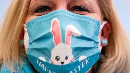 Eine Frau trägt im schleswig-holsteinischen Landtag einen Mund-Nasen-Schutz mit einem aufgedruckten Osterhasen.