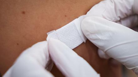 Eine Ärztin klebt nach einer Corona-Impfung ein Pflaster auf den Arm eines Impflings im Hamburger Impfzentrum. 